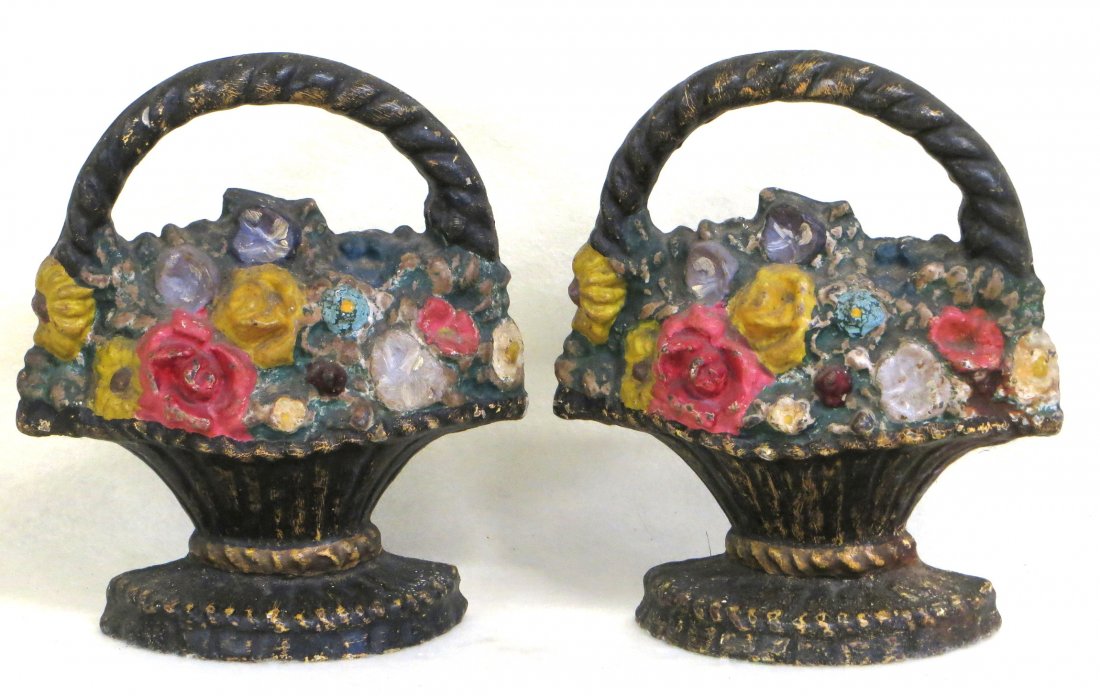 Two matching cast iron door stops of handled basket: Two matching cast iron door stops of handled basket with flowers - both appear to be in original paint with yellow base paint, in very good condition - 10"H. Provenance: From the Ann Phillips collecti