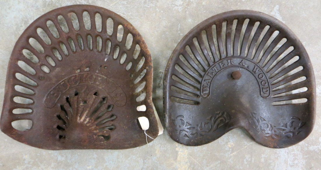 Two vintage cast iron tractor seats including a
