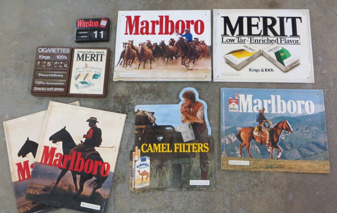 Grouping of six vintage mostly tin cigarette: Grouping of six vintage mostly tin cigarette advertising signs including 4 Marlboro, a Camel Filters, and a Merit sign - most appear to be from Stout Industries, Inc., St. Louis, Mo. - the plastic Mer
