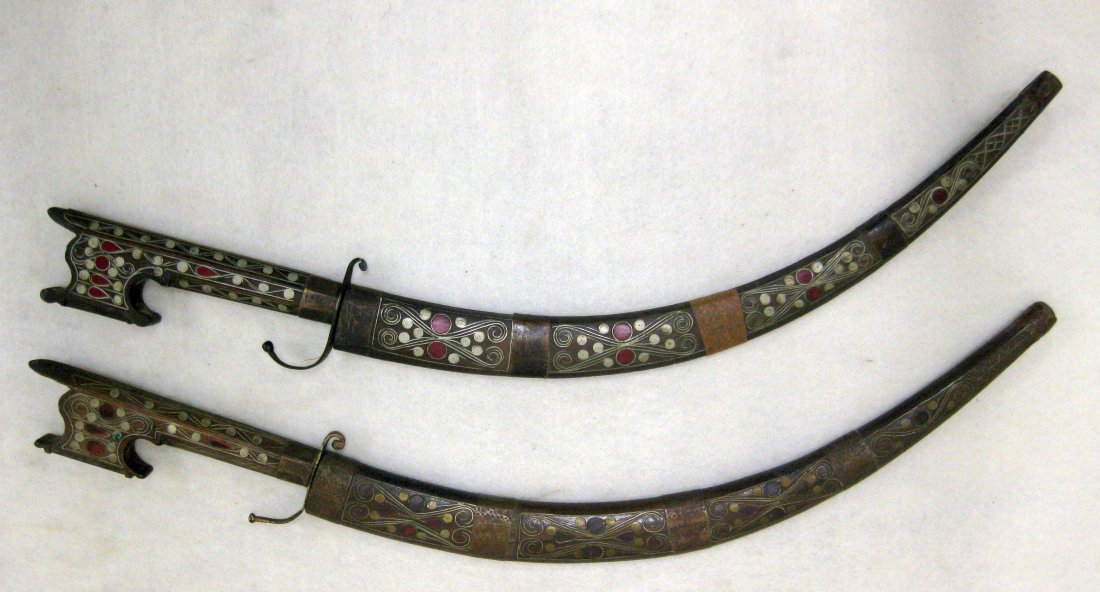 Matched pair of middle-eastern daggers with scabbards.: Matched pair of middle-eastern daggers with scabbards. Engraved blades. Gripes and scabbard with extensive wire & wood inlay. Blade length approximately 17".
