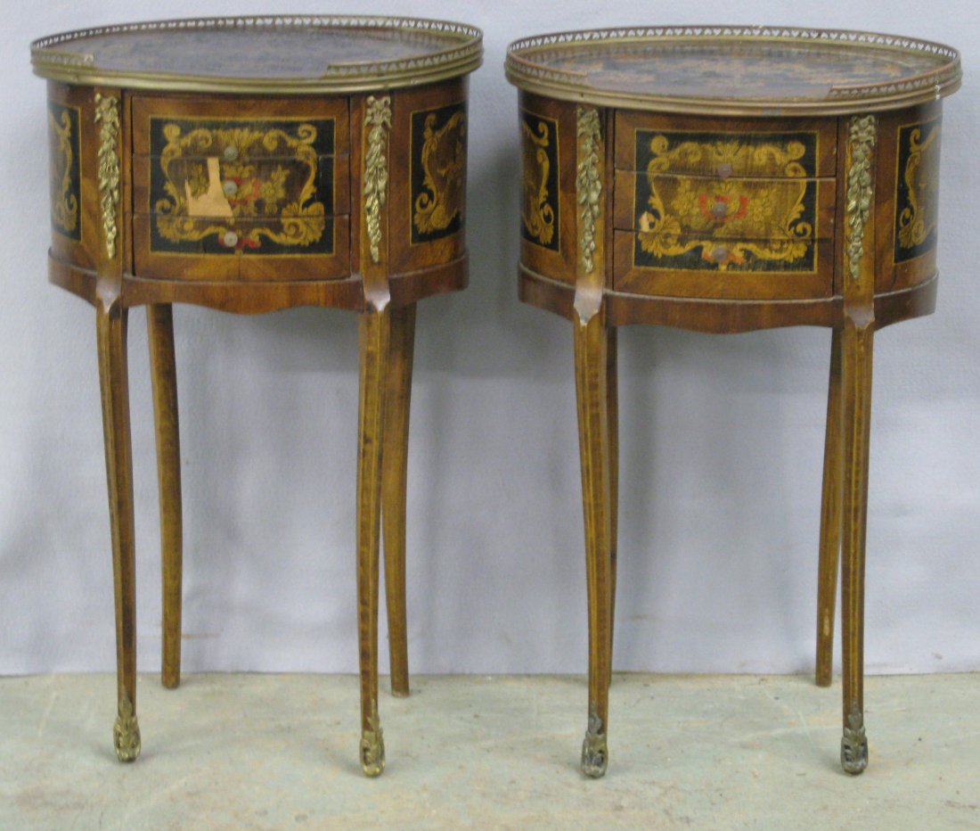 Pair of French style matching oval end tables. Each: Pair of French style matching oval end tables. Each with hand painted floral and scroll work on top, drawer fronts, and side panels. Brass gallery around tops with heart cutouts. Applied ormolu. Wear,