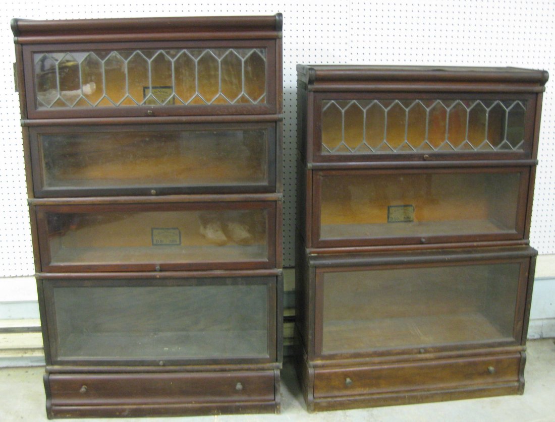 Two Globe Wernicke stacking mahogany bookcases, 3: Two Globe Wernicke stacking mahogany bookcases, 3 section and 4 section in mahogany - each with drawer in base and each with 1 section with leaded glass door. One top with some veneer damage. Overall 