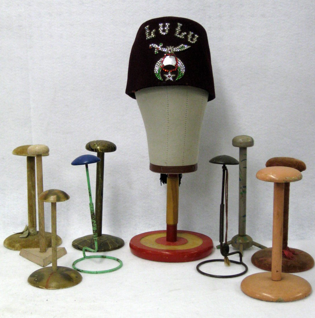 Collection of 9 hand made hat/bonnet stands, most in: Collection of 9 hand made hat/bonnet stands, most in wood in original paint and fabric mannequin head hat stand, together with a Masonic Shriner fez signed "LULU" on front - all decorations in colorle
