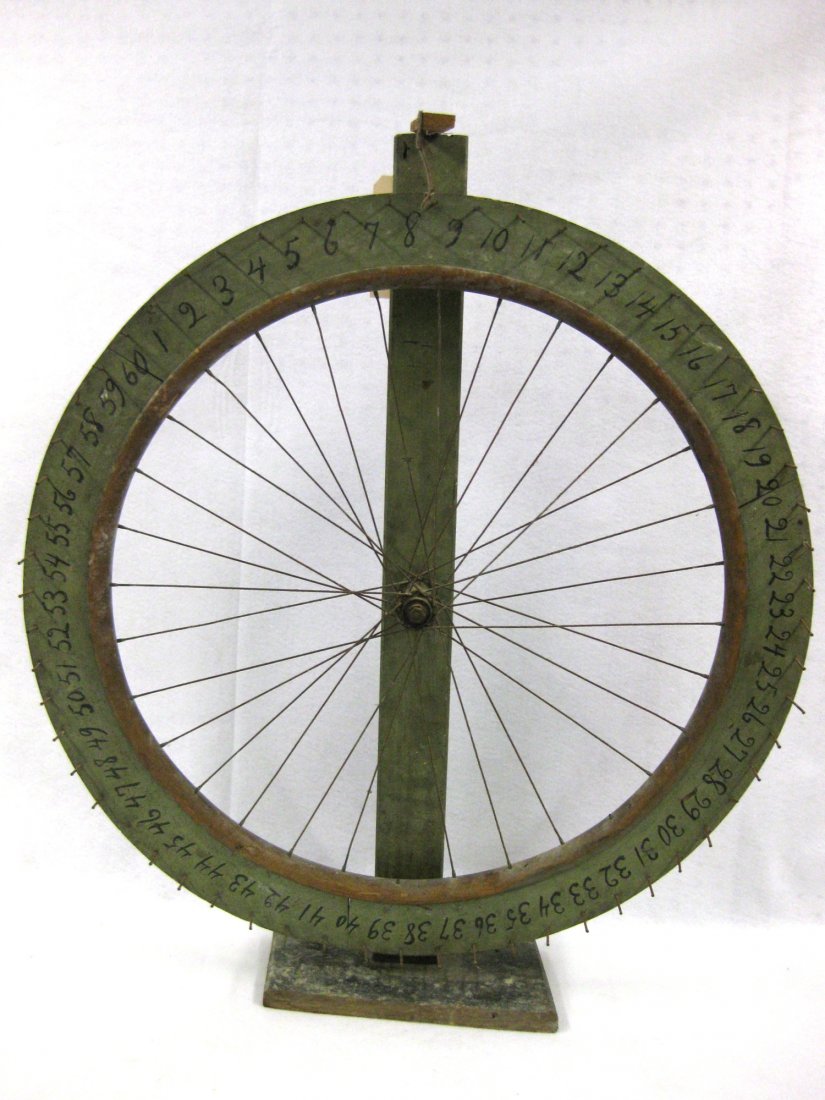 Old gaming wheel on original stand - made from an old: Old gaming wheel on original stand - made from an old bicycle wheel - original green paint with black lettering. Signed on reverse in old script "Assumption School - 872 N. Salina St." (Syracuse, NY) 