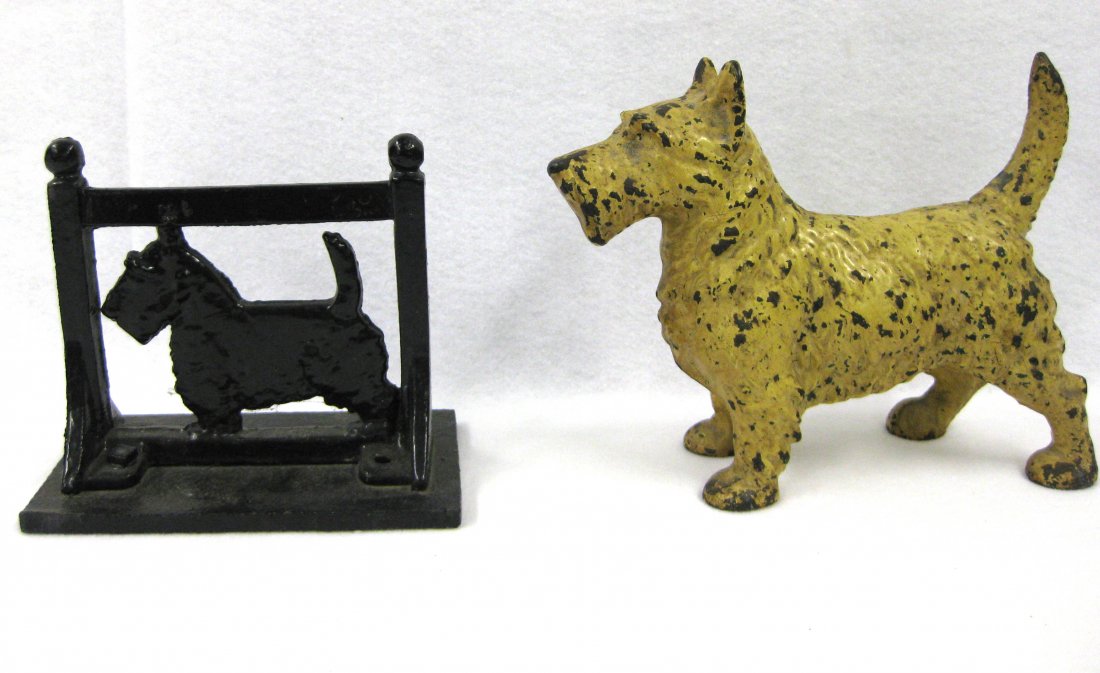 Cast iron Scottie dog door stop in original off-white: Cast iron Scottie dog door stop in original off-white paint - 10"L; together with a black Scottie dog boot scraper - 8"L x 7"H. Both in good condition.