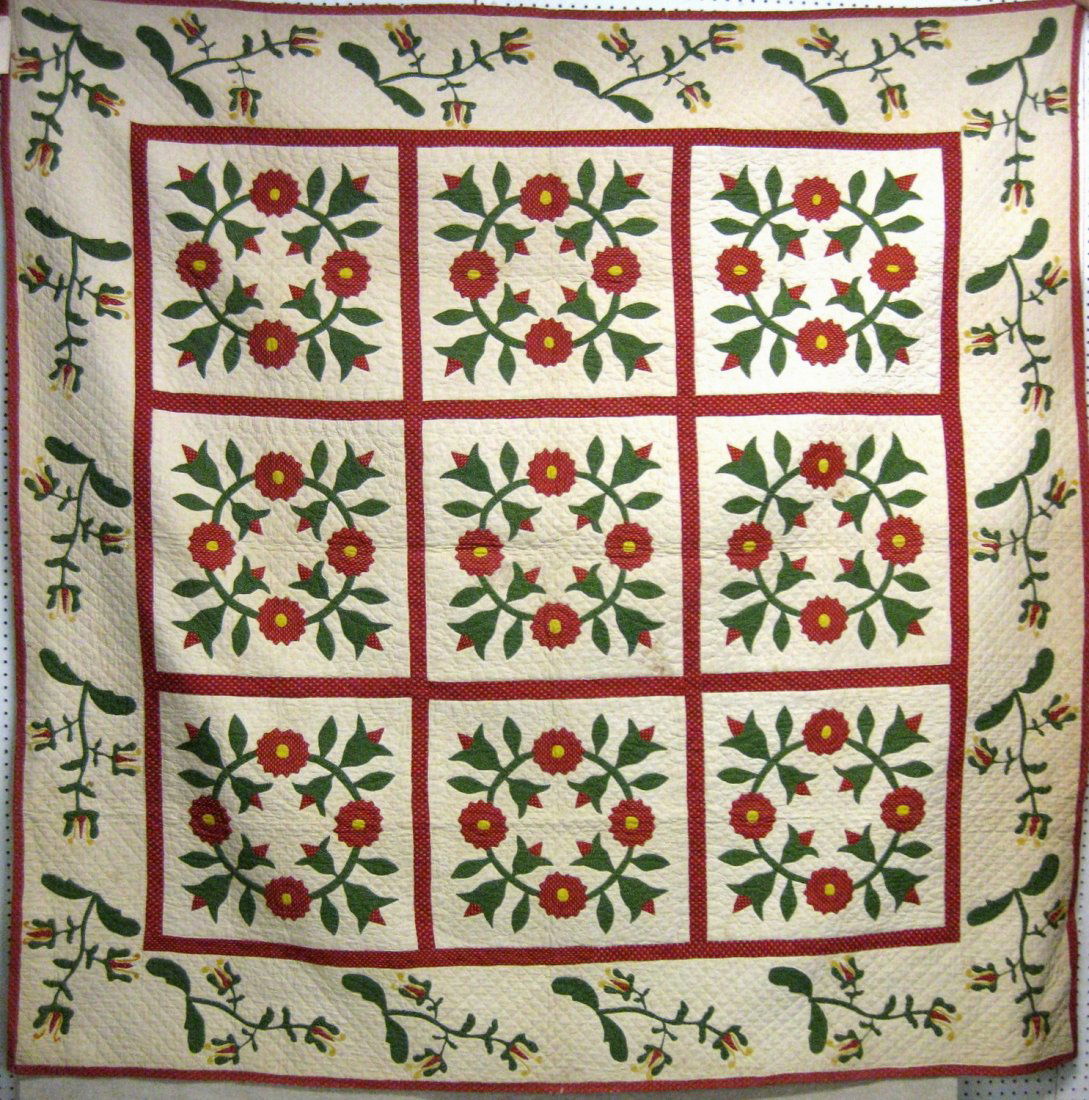 Appliqué quilt in "Rose Wreath" pattern with floral: Appliqué quilt in "Rose Wreath" pattern with floral border. Red, green, white and yellow colors. Minor loss to yellow yarn on perimeter flowers - minor fraying on edges. Overall, very good condition.