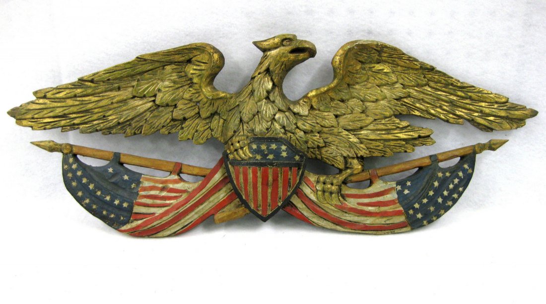 Carved wooden spread wing eagle wall plaque with 2: Carved wooden spread wing eagle wall plaque with 2 American flags flanking American shield held by talons of eagle. Possible touchups to gold leaf - red, white & blue appears to be original paint - re