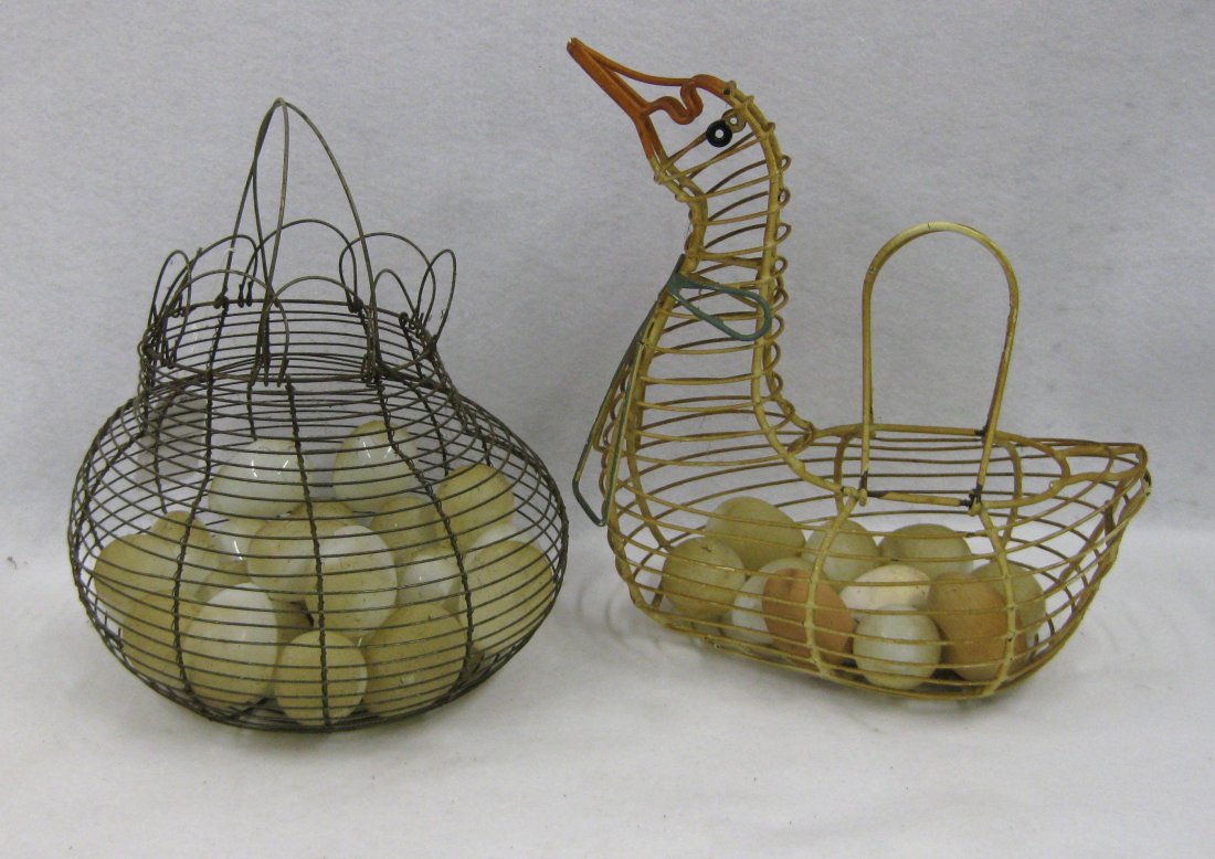 Two wire egg baskets filled with 29 hand blown eggs and: Two wire egg baskets filled with 29 hand blown eggs and 3 hand made wooden eggs (2 in brown and 1 in white paint). One pot shaped egg basket with double handles - approximately 9"H x 12"D, the other i