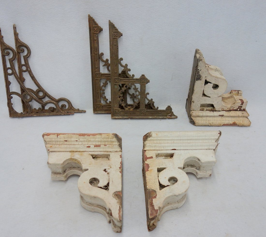 Grouping of wood and cast iron brackets including:: Grouping of wood and cast iron brackets including: Three wooden corbels in old white paint 9" L x 10" H; Two pair of cast iron brackets, the first measure 9" x 12", and the second measure 10" x 13.75"