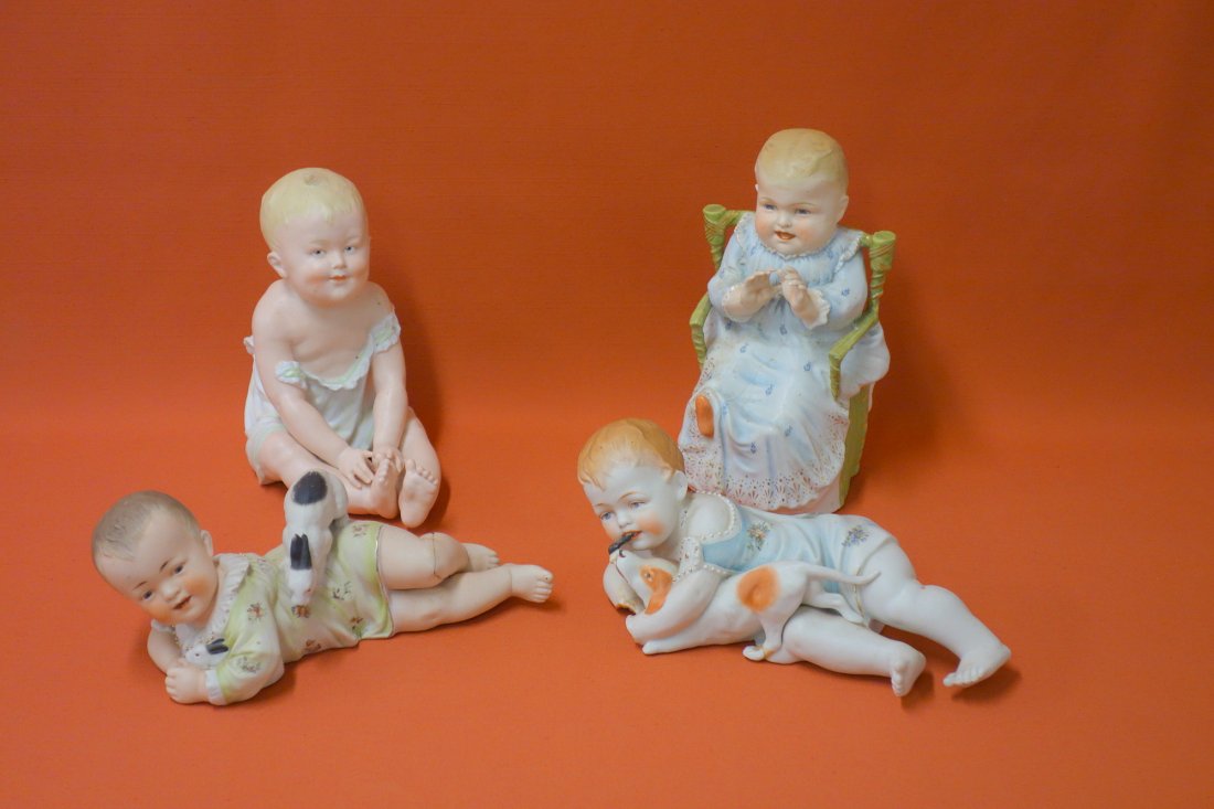 Four hand painted Victorian porcelain piano babies. The: Four hand painted Victorian porcelain piano babies. The seated baby in chair with hairline down front from ear to toe, resting baby reglued & loss to hand, baby with rabbit with repair to leg, seated 