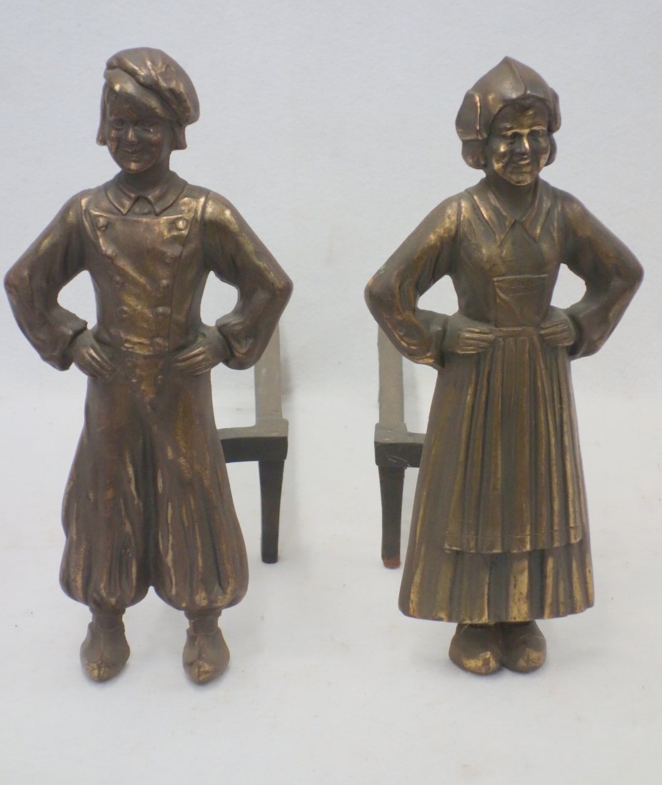 Pair of early 20th century cast iron figural andirons: Pair of early 20th century cast iron figural andirons of a Dutch man and woman, with faux bronze plating, marked "3694" on the back of the figures and "1919" on the underside of the dogs, 16" H. Very 
