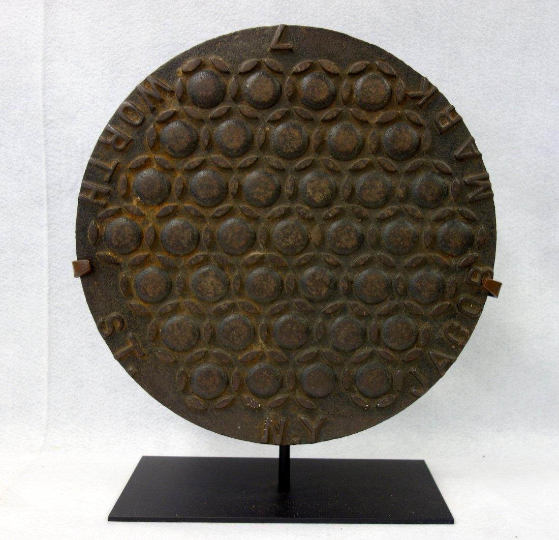 Cast iron coal chute cover with address marked "7 WORTH: Cast iron coal chute cover with address marked "7 WORTH ST. / JACOB MARK" - 17.5"D. Probably Brooklyn NY. Very good original condition. Displayed on a museum iron mount.