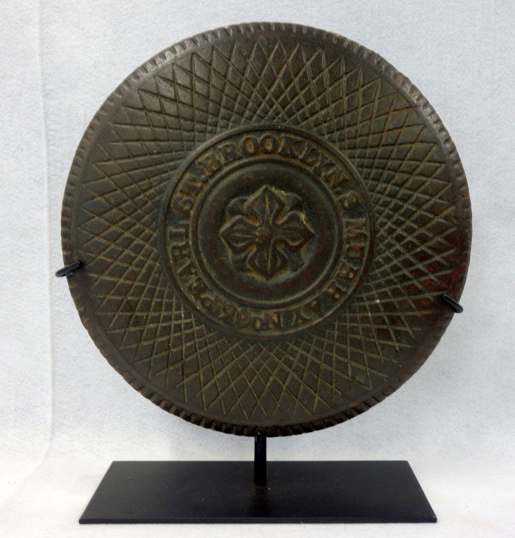 Cast iron coal chute cover marked with address "S: Cast iron coal chute cover marked with address "S MURRAY. No. 65. PEARL ST. BROOKLYN" - 16"D. Very good original condition. Displayed on a museum iron mount.