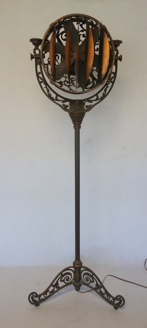 Ornate cast iron fan ,"Luminaire" manufactured by the: Ornate cast iron fan ,"Luminaire" manufactured by the Cincinnati Victor Co.. 54 3/4"H. Note: there is a break to the casting on the back of the fan, 2 other minor losses to scroll work on sides, chips