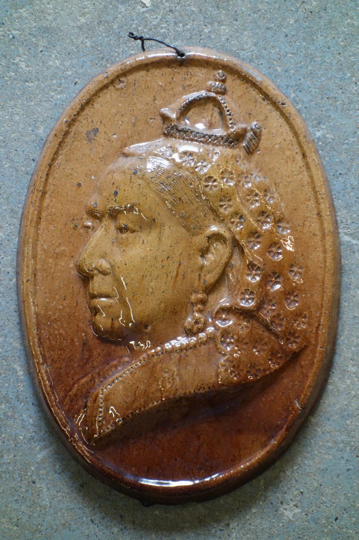 An earthenware wall plaque with sponge brown glaze,: An earthenware wall plaque with sponge brown glaze, depicting Queen Victoria - 9 1/4" x 13", probably 19th century. Small glaze chip on underside of rim, otherwise good condition. Provenance: Sam and