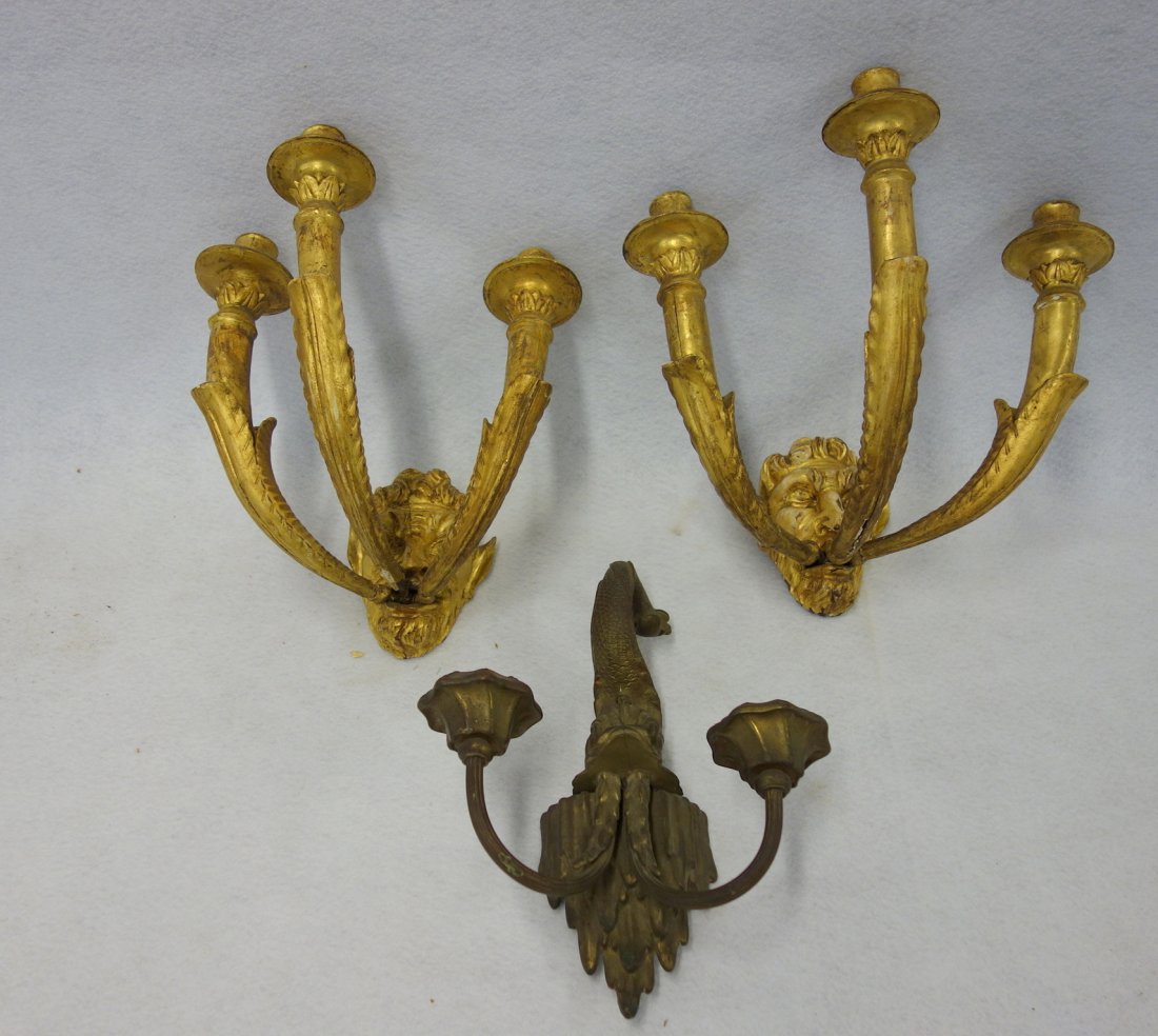 Three decorative wall sconces including a pair of: Three decorative wall sconces including a pair of carved gilt wood with 3 branches extending from a devil's face, 19th century, some chips and cracks, fair to good condition; and a single brass dolphi