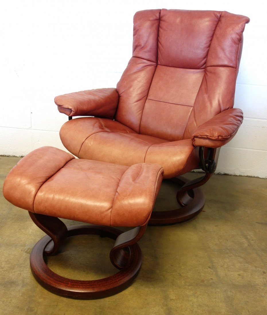 Ekornes Stressless Norwegian reclining red leather: Ekornes Stressless Norwegian reclining/revolving red leather chair with wooden base and matching ottoman. Some fading of leather, else good condition.