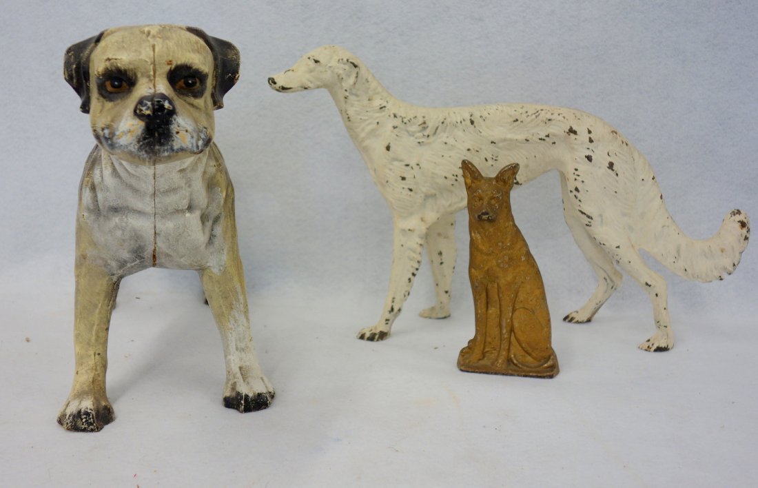 Three cast iron dog doorstops including: a Greyhound: Three cast iron dog doorstops including: a Greyhound 16"L in old white paint; a Bulldog 16"L; and a seated German Sheppard 6 1/2"H. All appear to be early to mid 20th century and in good condition.