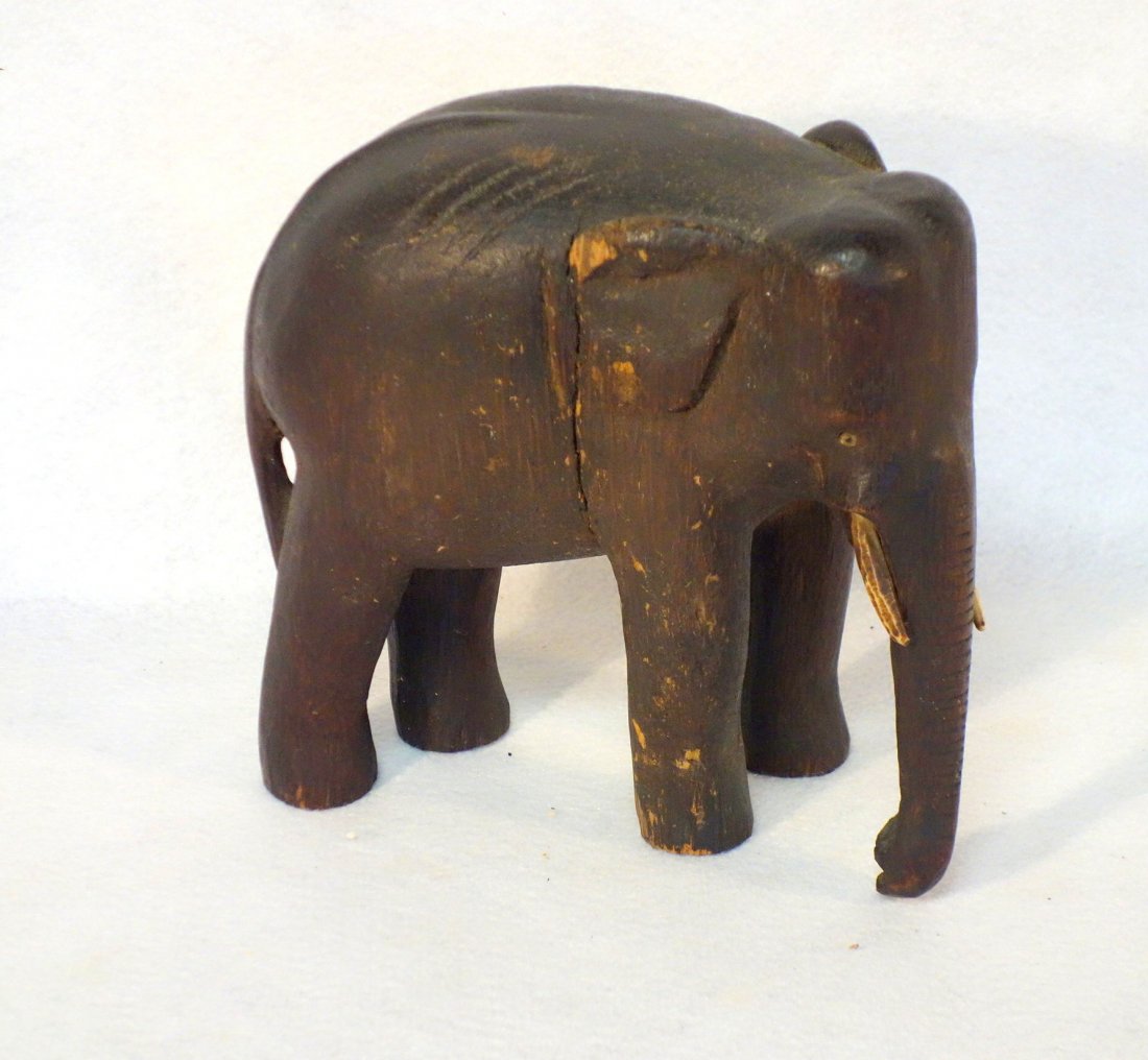 Very fine carved folk art elephant in original old: Very fine carved folk art elephant in original old finish - bone tusks and eyes - 19th century. Small age check, slight surface chips to one ear, else very good original condition. 8.5"L x 8"H.