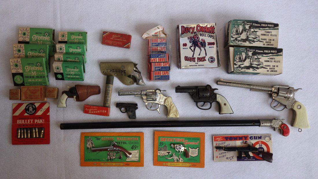 Grouping of cap guns & related toys including boxes of: Grouping of cap guns & related toys including boxes of unused caps, several western cap guns, C-Boy cast iron cap gun, 2 Premier die cast metal 75mm cannon toys in original box, signed "H" walking sti