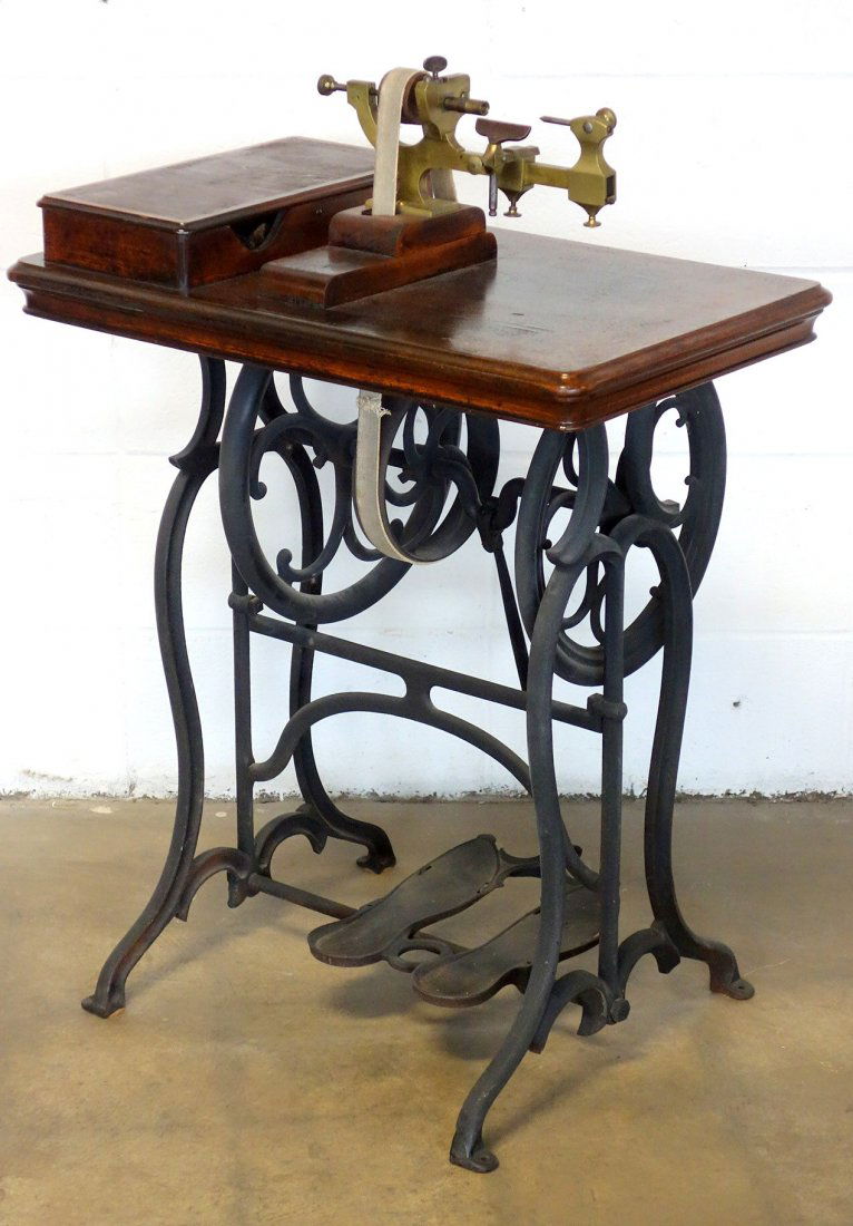 Jeweler's lathe driven by foot power with an optional: Jeweler's lathe driven by foot power with an optional wheel for connection to steam engine - brass with wooden storage compartment and top, supported by a cast iron frame with foot pedals. Comes with