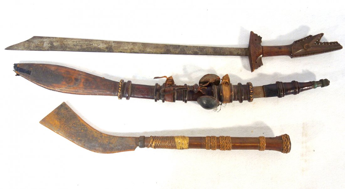 Three ethnographic weapons including a Moro Kampilan: Three ethnographic weapons including a Moro Kampilan Sword, Philippines Islands - loss to bottom edge of wooden handle (see photo) - blade in good condition - 28.5"L; a tribal machete, late 19th centu