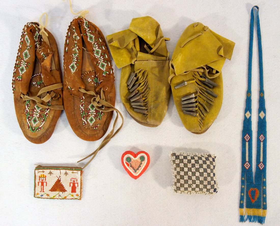 Grouping of Native American articles including 2 pair: Grouping of Native American articles including 2 pair of moccasins (one pair beaded the other pair with metal ornaments), 2 beaded pin cushions, and a beaded necklace.