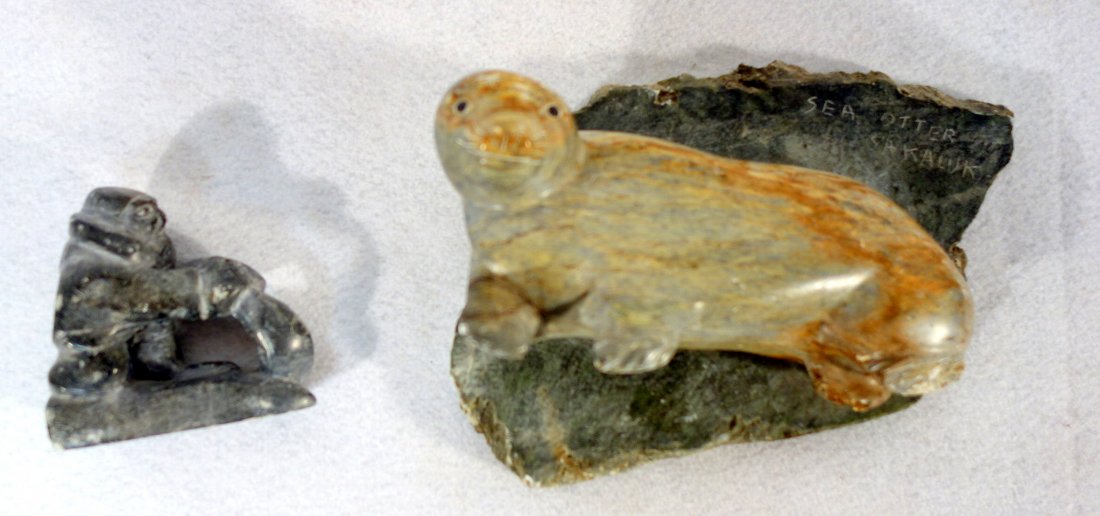 Two Inuit stone carvings including Eskimo lifting seal: Two Inuit stone carvings including Eskimo lifting seal signed Nowya - 3.75"W - good condition; together with a sculpture of a Sea Otter signed Sakaluk - 8.5"L - glue repair to front leg, minor abrasio