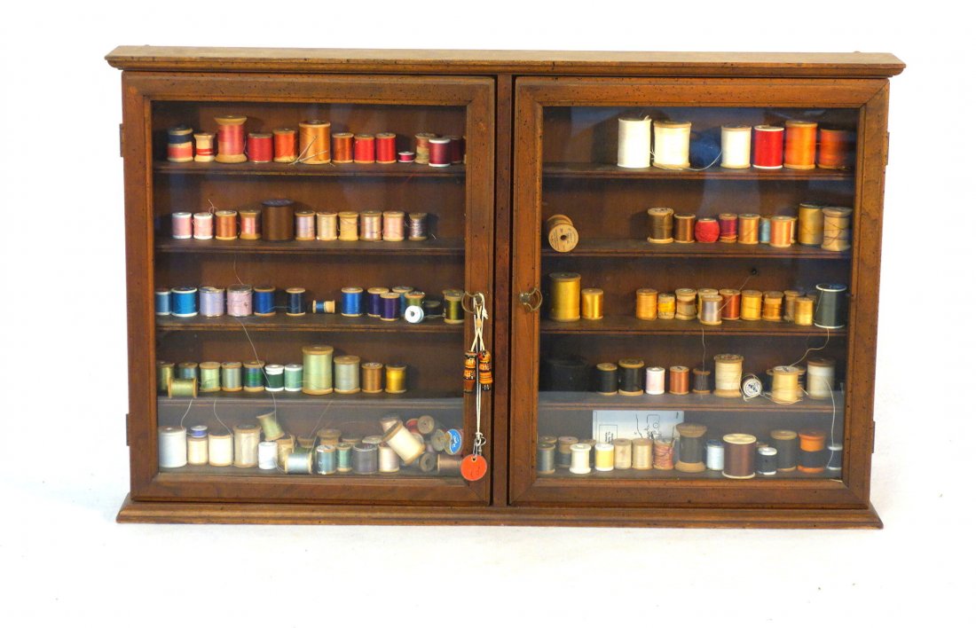 Sewing wall mounted spool cabinet have 2 glass doors -: Sewing wall mounted spool cabinet have 2 glass doors - 35"L x 21.5"H x 4"D - currently filled with sewing thread. Probably late 20th century in very good condition.