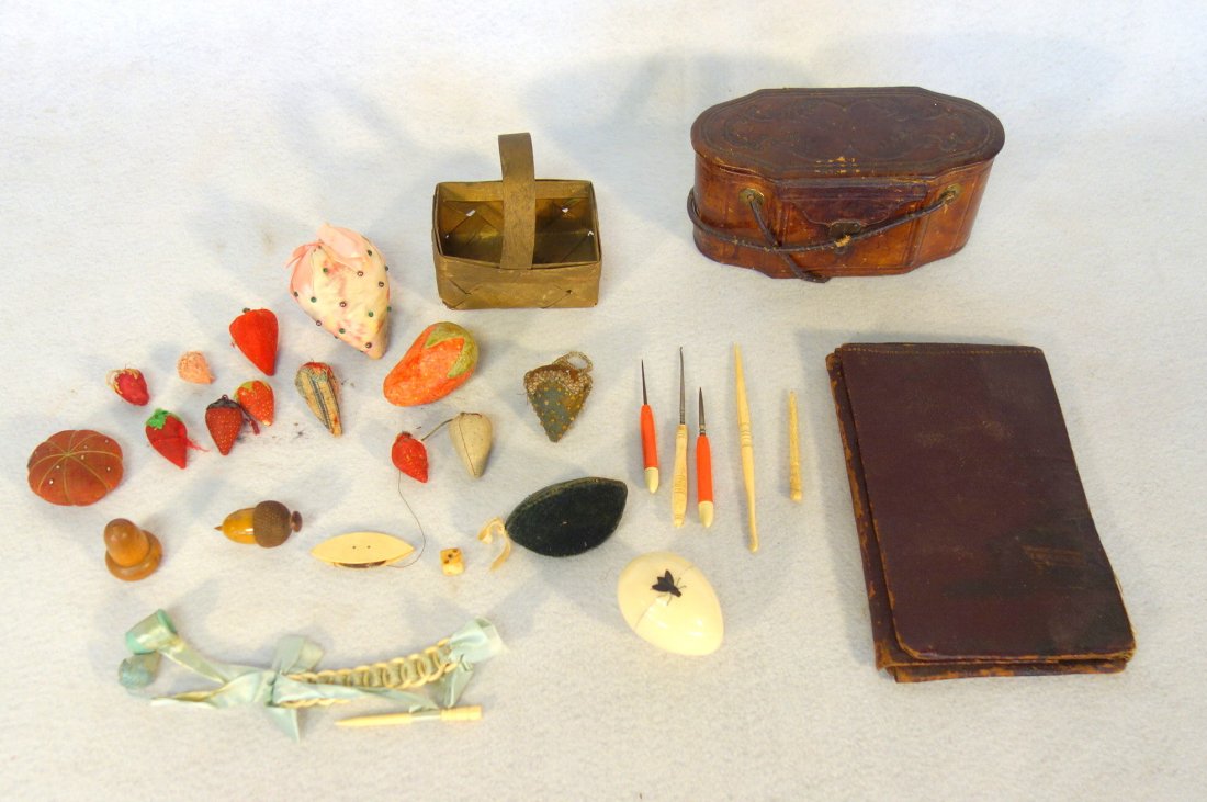 Grouping of sewing related articles including egg: Grouping of sewing related articles including egg shaped tape measure with figural fly finial (pull fly to expose tape), chestnut shaped wooden thimble case (souvenir of Jerusalem), pin cushions inclu