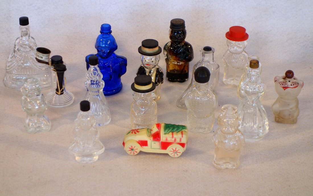 Grouping of 16 miniature figural bottles including: Grouping of 16 miniature figural bottles including scent, candy, etc. Includes one celluloid Santa Claus rattle and telephone form candy container.