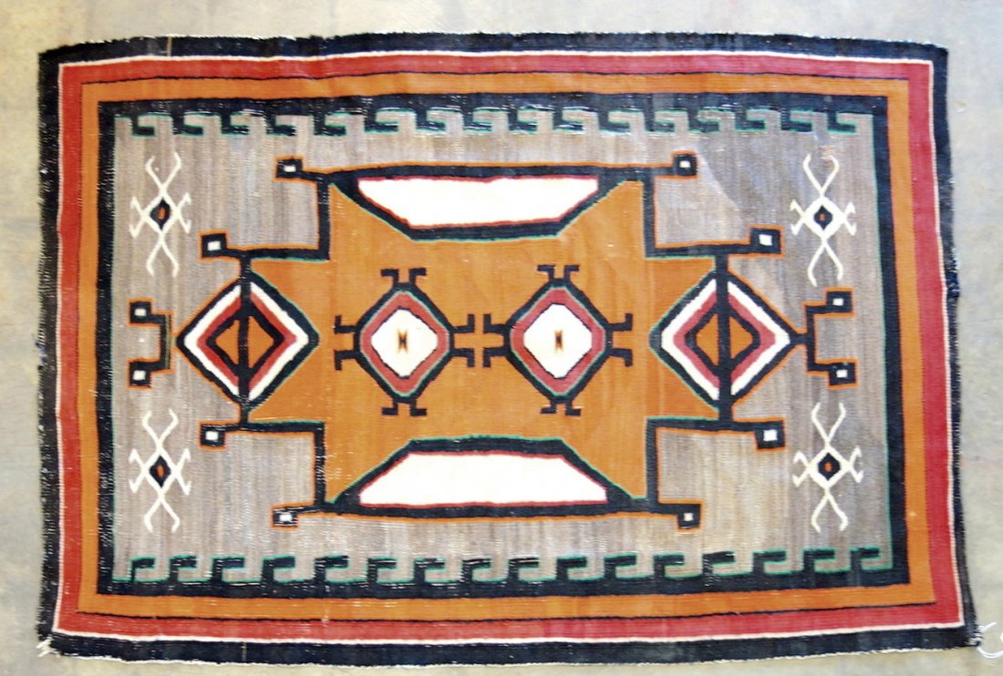 Navajo scatter rug with central medallion in red, rust,: Navajo scatter rug with central medallion in red, rust, beige, green and black colors. Late 19th to early 20th century. Possible fraying on one end as it has been folded over and sewn, also one small 