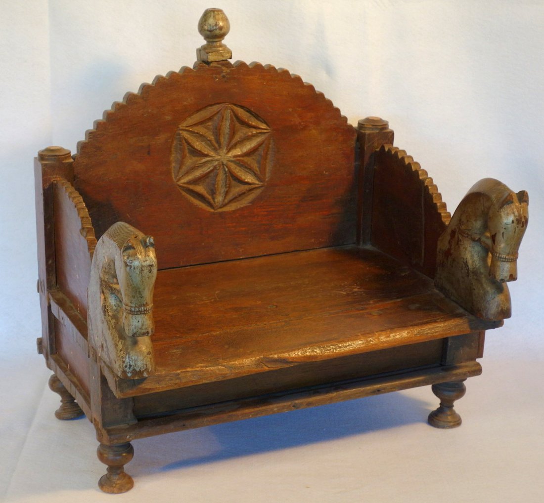 Small primitive stand/bench with rounded and stepped: Small primitive stand/bench with rounded and stepped wooden back with a hand carved central floral medallion - also having 2 carved horse head arms in old gray paint, over hidden lower shelf with slid