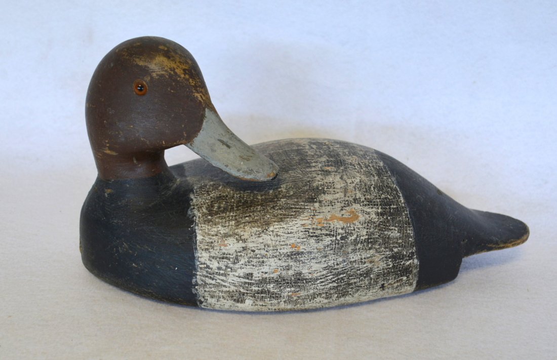Redhead decoy with turned head in the style of William: Redhead decoy with turned head in the style of William Rumble, St. Lawrence River school of carvers. Late 19th century. See paper label on reverse. The back of the decoy has been scraped down to the o