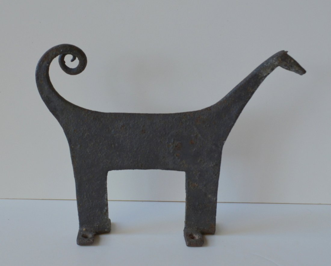 Folk art hand forged iron boot scraper in the form of a: Folk art hand forged iron boot scraper in the form of a stylized dog with curled tail - late 18th to early 19th century - traces of original paint - very good condition - 9.5"W x 7"H.