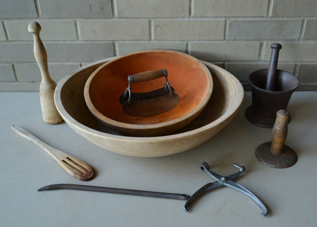 Grouping of country items including 2 treenware bowls: Grouping of country items including 2 treenware bowls (the largest 5.25"H x 18"D), cast iron mortar & pestle, hog scraper, food chopper, single cherry pitter, wooden pestle & wooden mixer, and a hand 