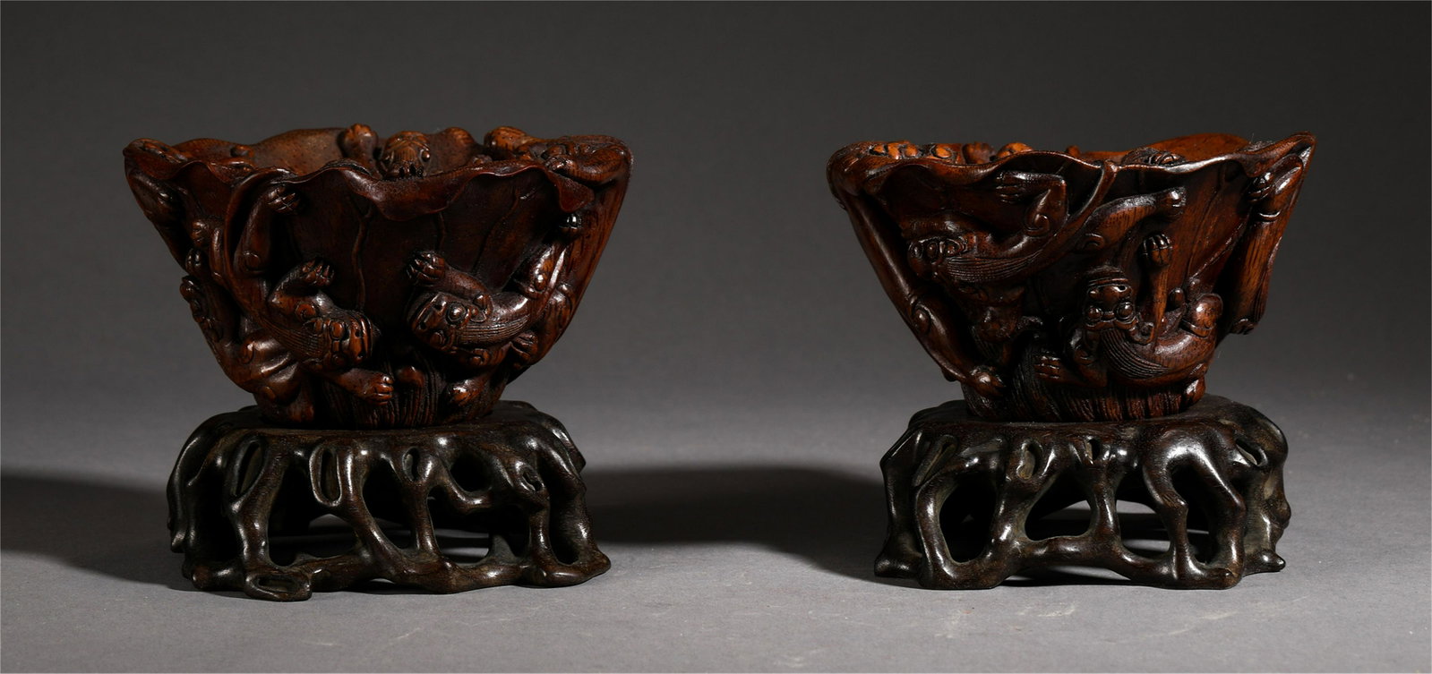 A PAIR OF CHINESE AGARWOOD BEAST PATTERN CUP: H. 9 cm. L. 11.5 cm. W. 9.5 cm. Total Weight 380 gram.