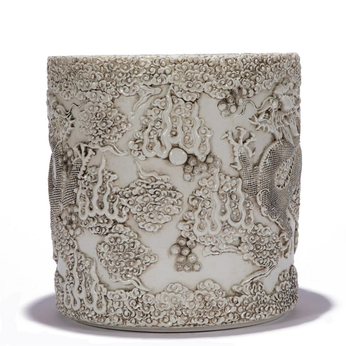 A CHINESE WHITE PORCELAIN CARVED DRAGON BRUSH POT: W. 25 cm. H. 25 cm. Weight 5440 gram.