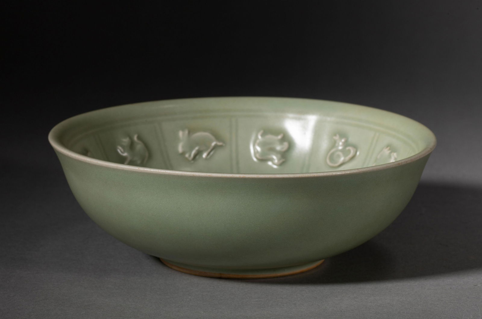 A CHINESE CELADON GLAZED PORCELAIN TWELVE ANIMALS BOWL: L. 17.5 cm. W. 17.5 cm. H. 6 cm. Weight 560 gram.