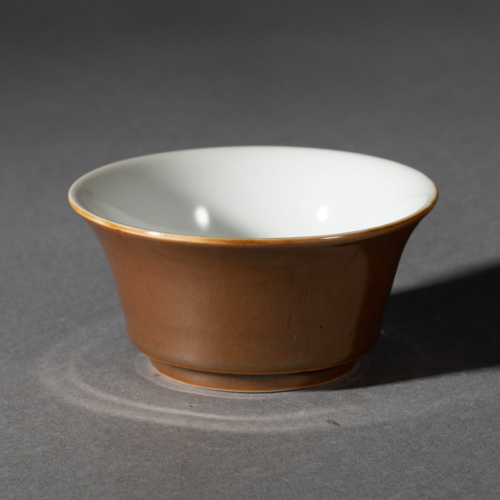 A CHINESE BROWN GLAZE PORCELAIN CUP: L. 8.3 cm. W. 8.3 cm. H. 4.3 cm. Weight 70 gram.