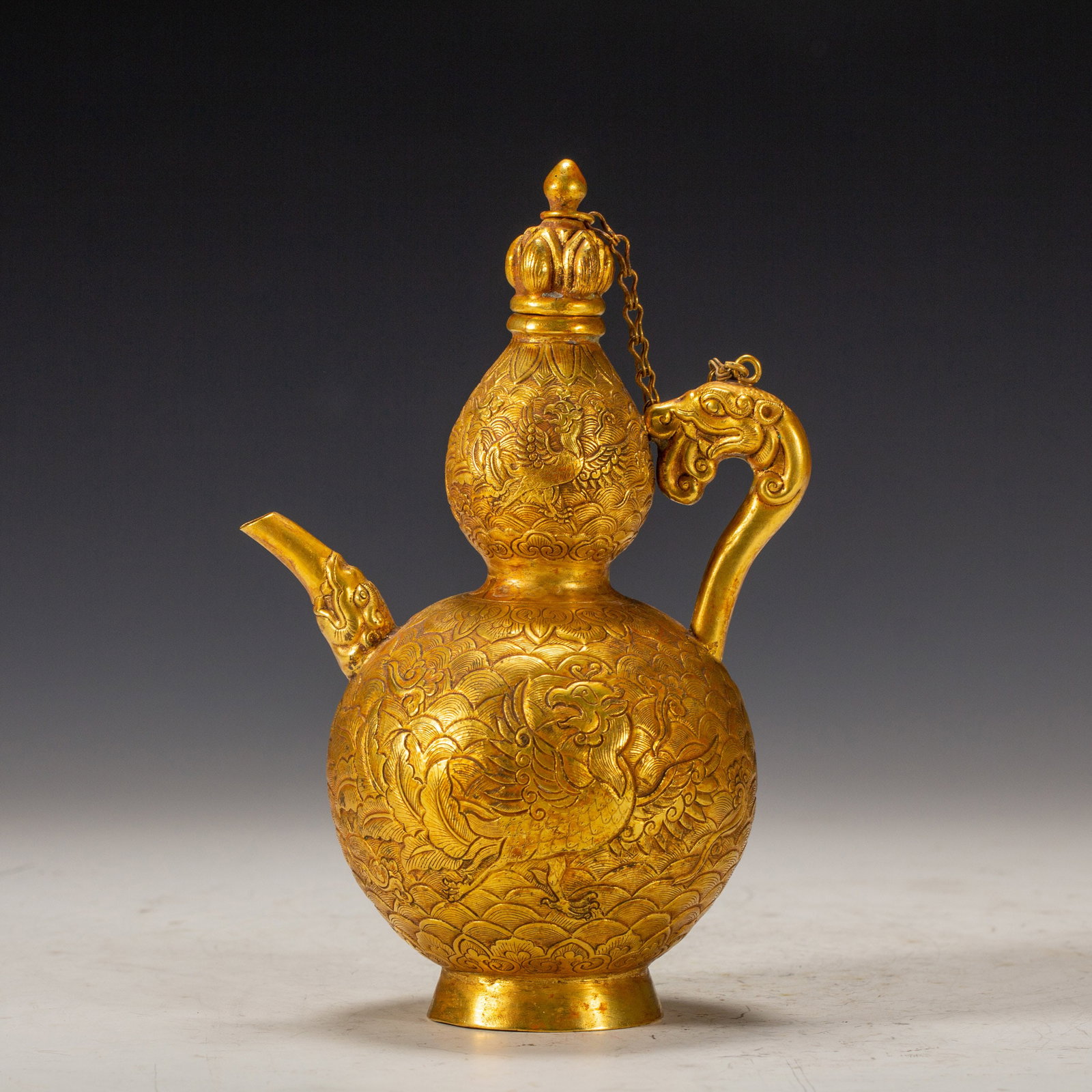 AN ENGRAVED BRONZE-GILT KETTLE: L. 12 cm. W. 8.5 cm. H. 18 cm. Weight 390 grams.