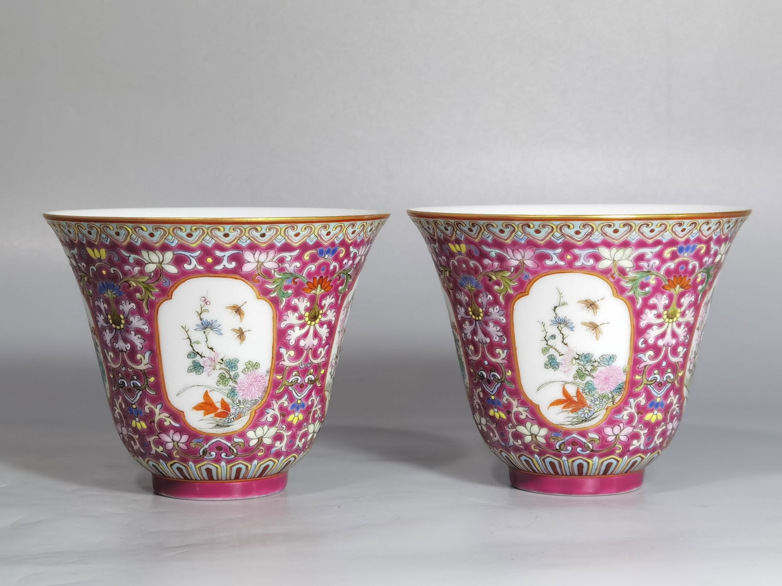 A Pair of Chinese Red Ground Famille-Rose Porcelain Cups: A Pair of Chinese Red Ground Famille-Rose Porcelain Cups. Diam. 9.6cm, Ht. 7.8cm