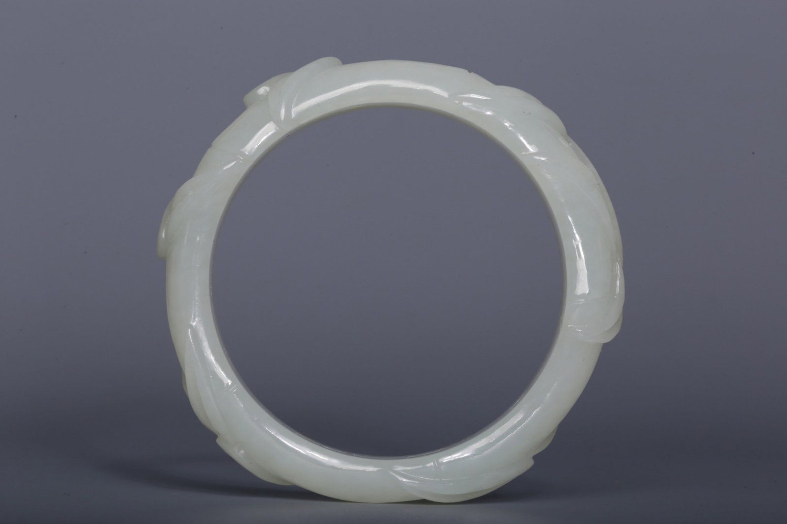 A Chinese Carved Jade Bangle: A Chinese Carved Jade Bangle. Diam. 7.9cm, Internal Diam. 5.8cm, Wd. 1.7cm, Wt. 63g