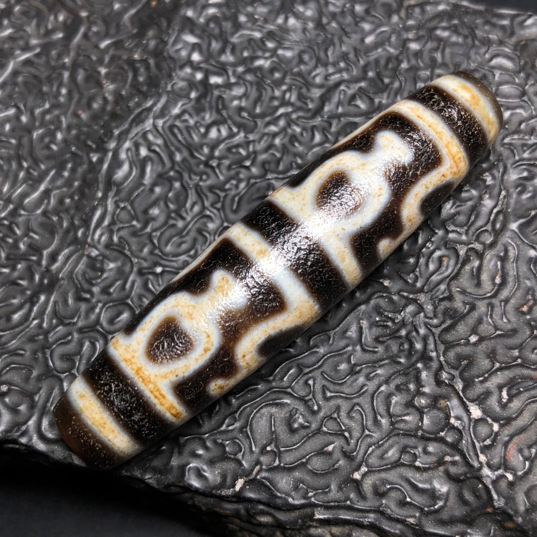 A Chinese Carved Agate DZI Bead with Bronze Figure of Buddha: A Chinese Carved Agate DZI Bead with Bronze Figure of Buddha. Lg. 5.7cm, Diam. 1.3cm, Wt. 14.8g