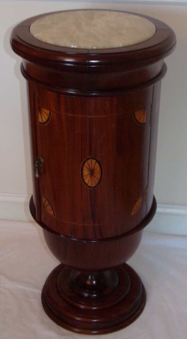 Mahogany Cabinet on Pedestal: Modern round mahogany cabinet mounted on a pedestal base, 4 pieced molded top w/polished stone insert similar to onyx over 1 door, door & cabinet decorated w/fan form inlay, marked on inside of door a