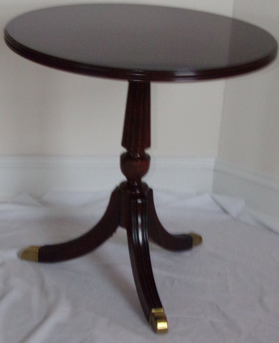 Stylized Duncan Phyfe Stand: Stylized Duncan Phyfe mahogany stand having a round molded top over a pedestal base w/reeded design on 3 legs ending in brass feet by Land Furniture Co., style #1556-06, 23 1/2" T x 34" diameter