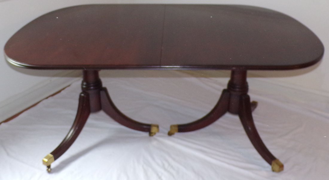 Stylized Dining Room Table: Stylized Duncan Phyfe cherry dining room extension table w/molded edge & curved ends, the base w/2 turned pedestals each ending on 3 legs w/brass feet & castors, no maker's name found, 28 1/2" T x 64
