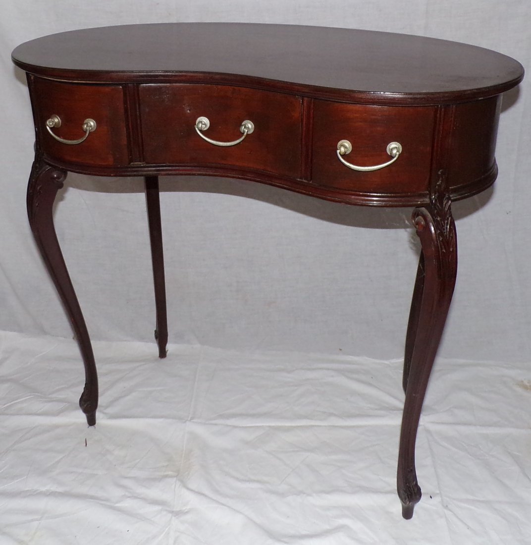 20th C Kidney Shaped Table: 20th C small mahogany kidney shaped table w/3 drawers on cabriole legs ending in scrolled toes, machine leaf carved design on knees, metal bail pulls & custom fitted glass top, oak secondary wood, 28