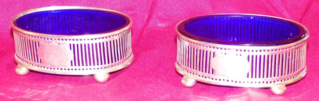 Pair of Sterling Silver Master Salts: Pair of oval sterling silver master salt cellars, vertical reticulated slat form design on footed bases, each with cobalt blue glass inserts, #948, monogrammed, each 1 Â¼Â” T x 3 Â¼Â” W x 2 