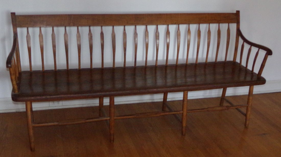 19th C Country Settee: 19th C. country bent arrowback plank seat settee, 19 arrowbacks and 3 under each arm on turned legs w/ring design joined by stretchers, old damage and repair where arm joins back post, upper right pos